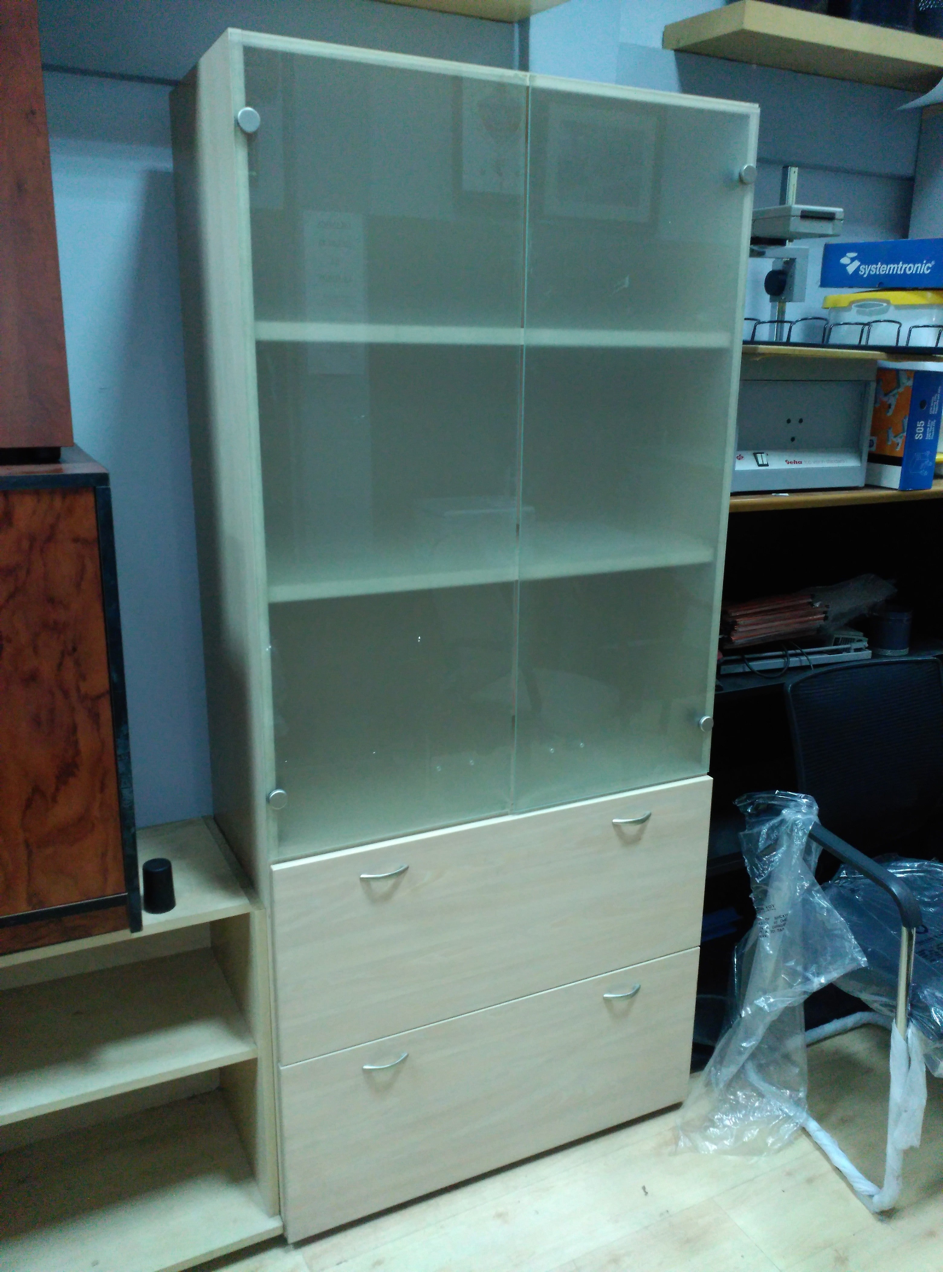 Armario alto con puertas de cristal.