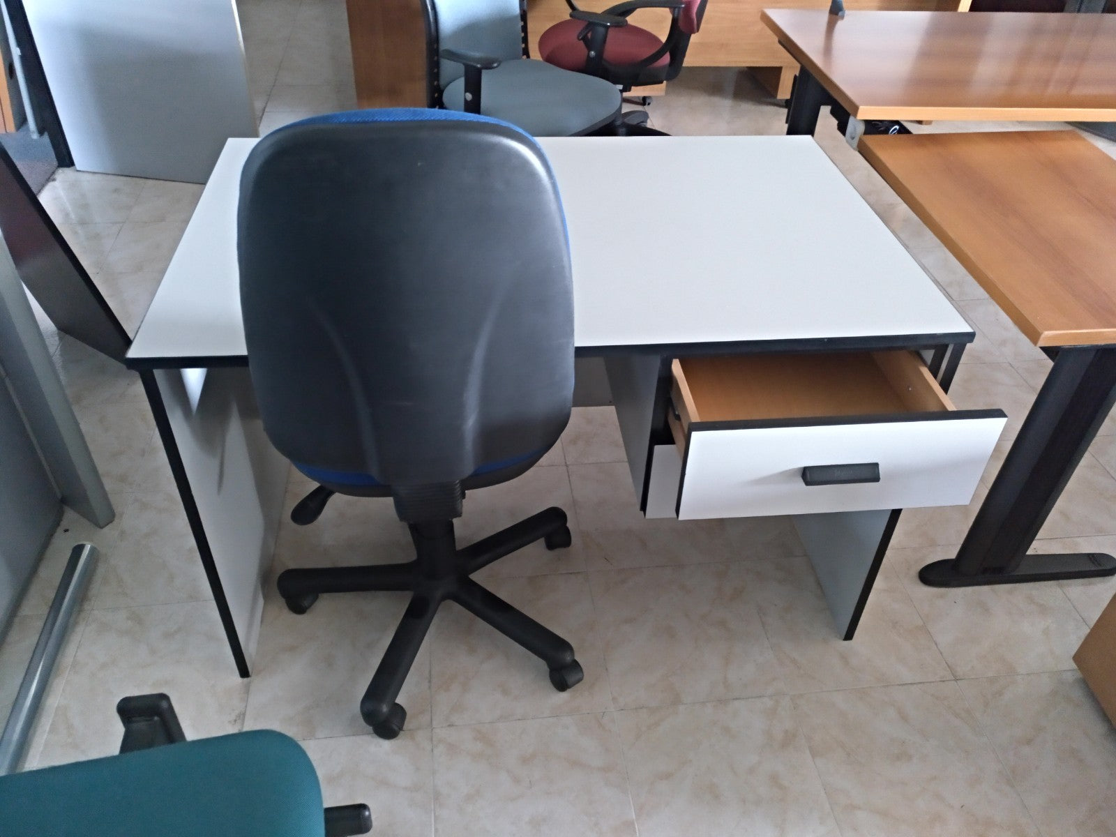 Mesa recta gris con cajonera.