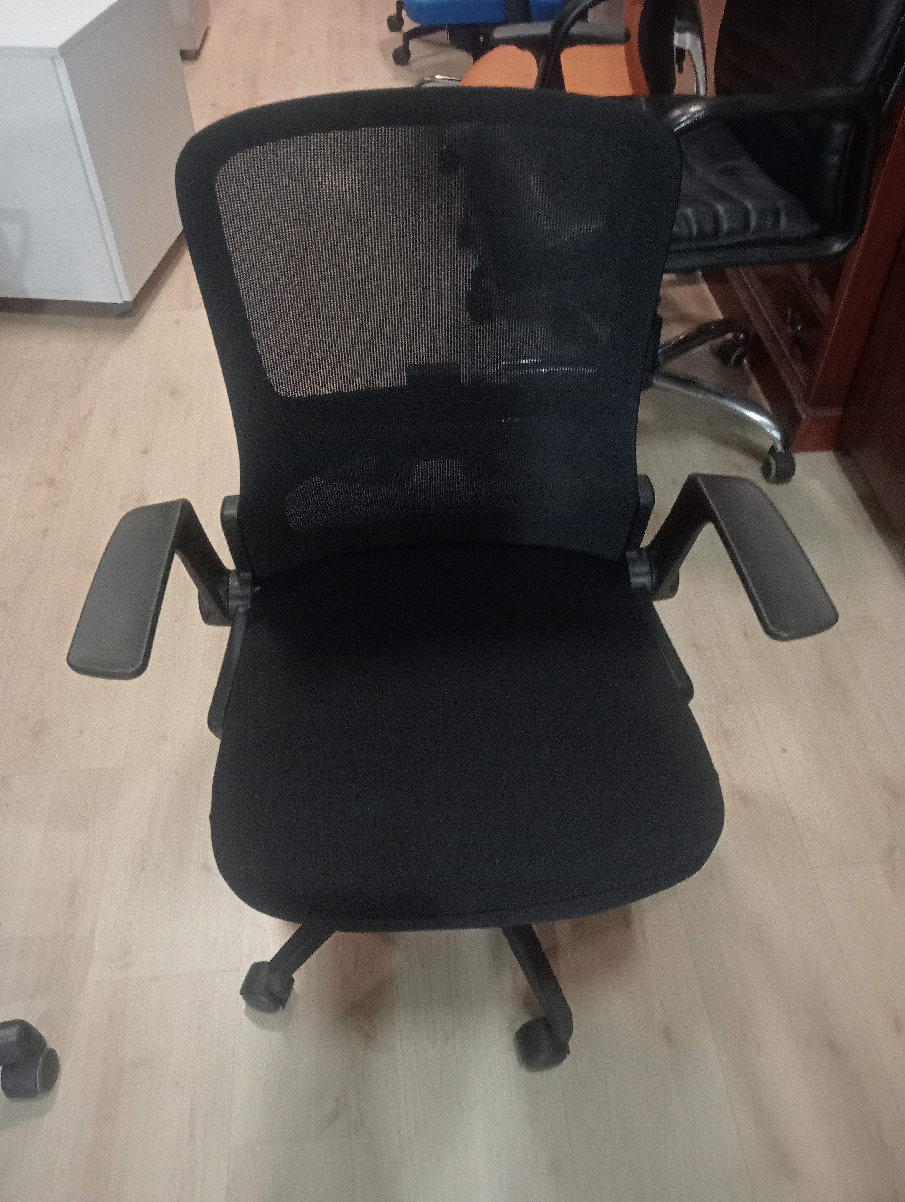 Silla giratoria con brazos abatibles.