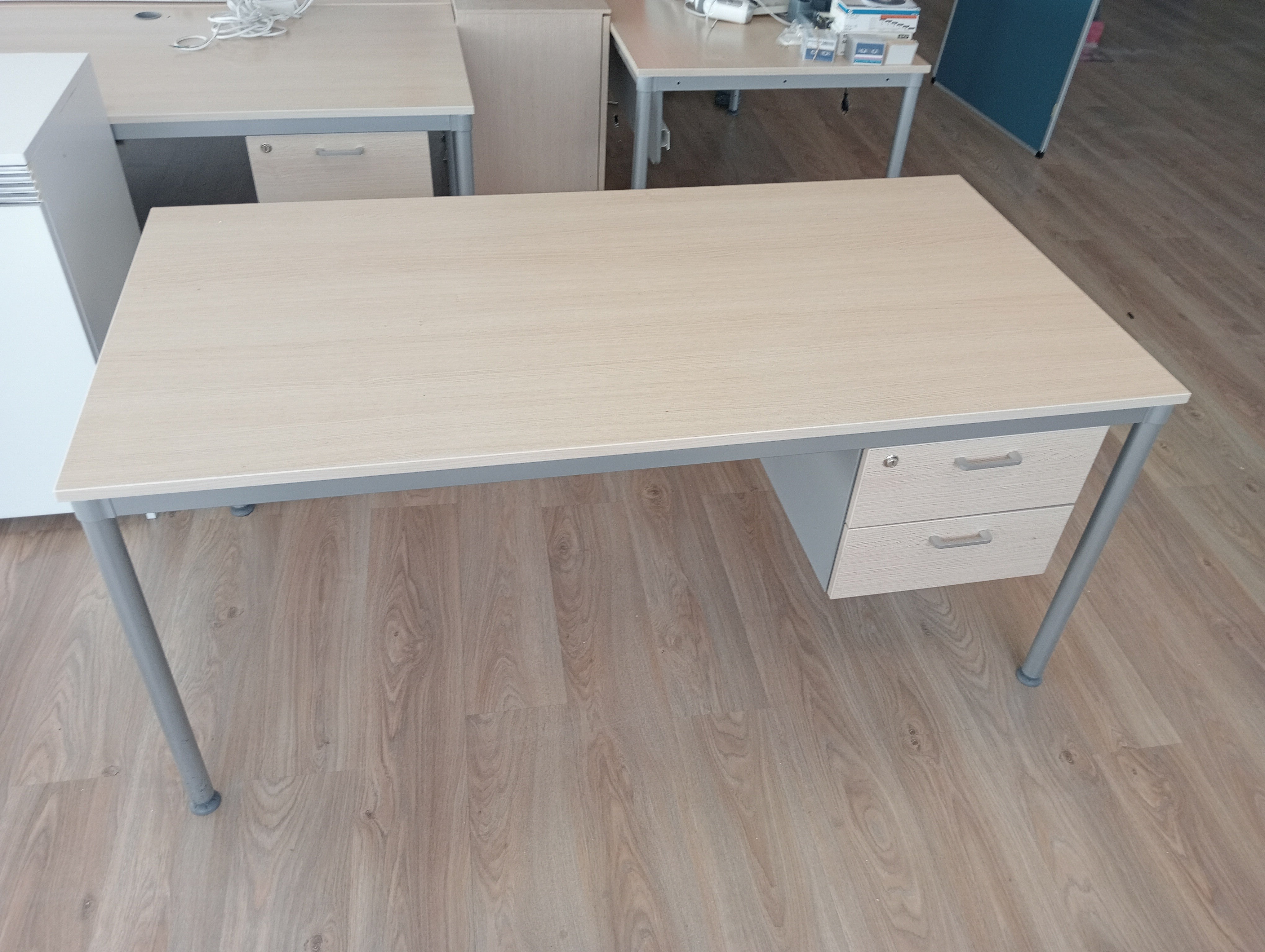 Mesa recta con cajonera colgada.