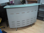 Mostrador curvo con frente metálico.