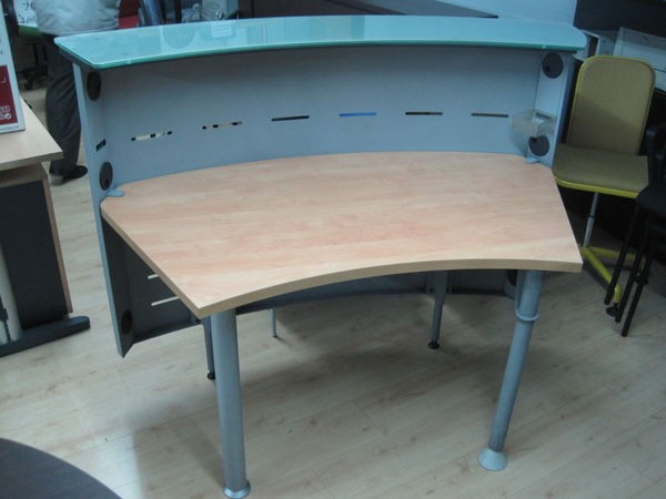 Mostrador curvo con frente metálico.