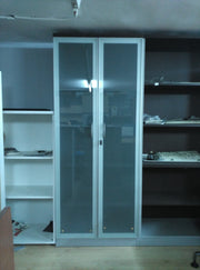 Armario alto con puertas de cristal.