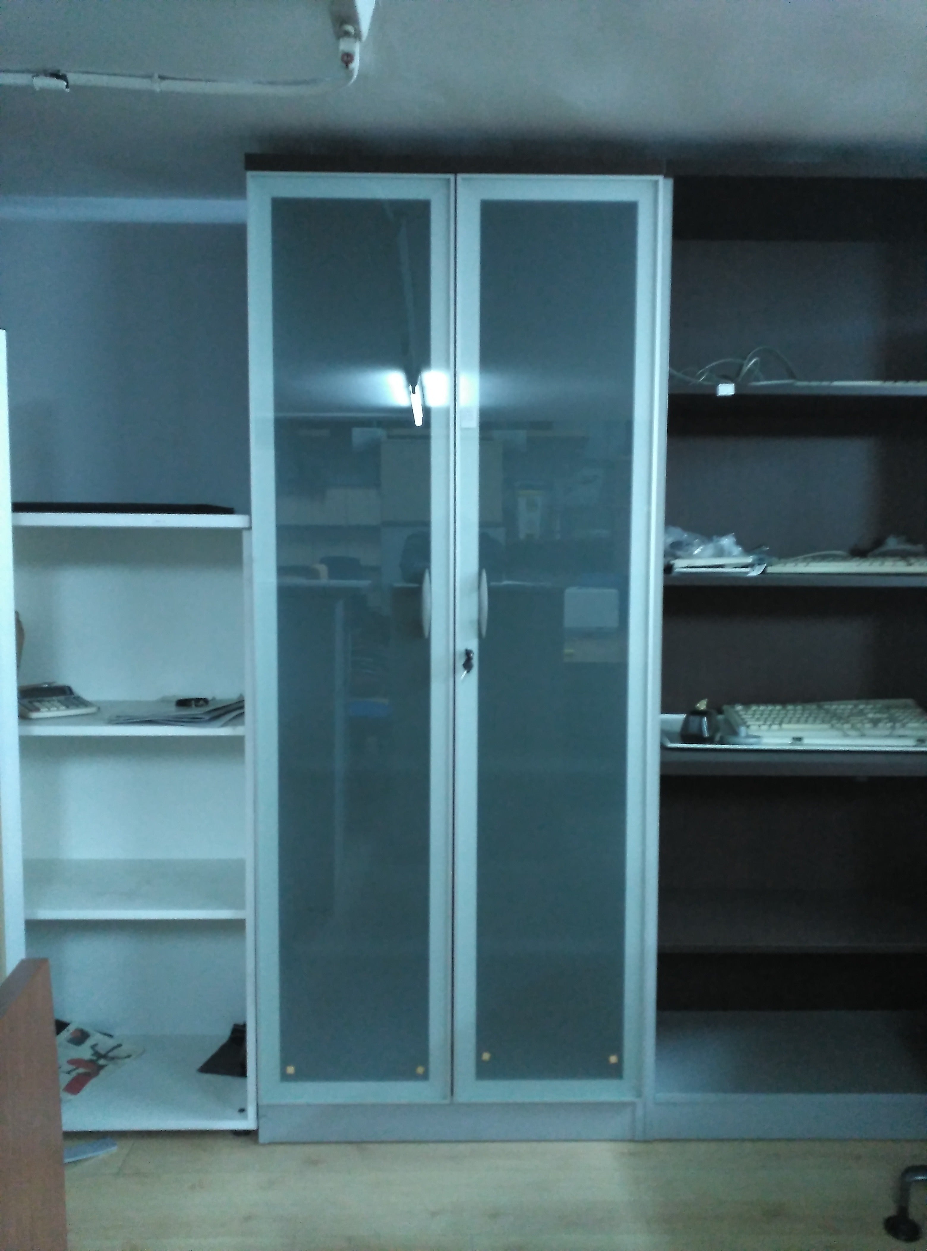 Armario alto con puertas de cristal.