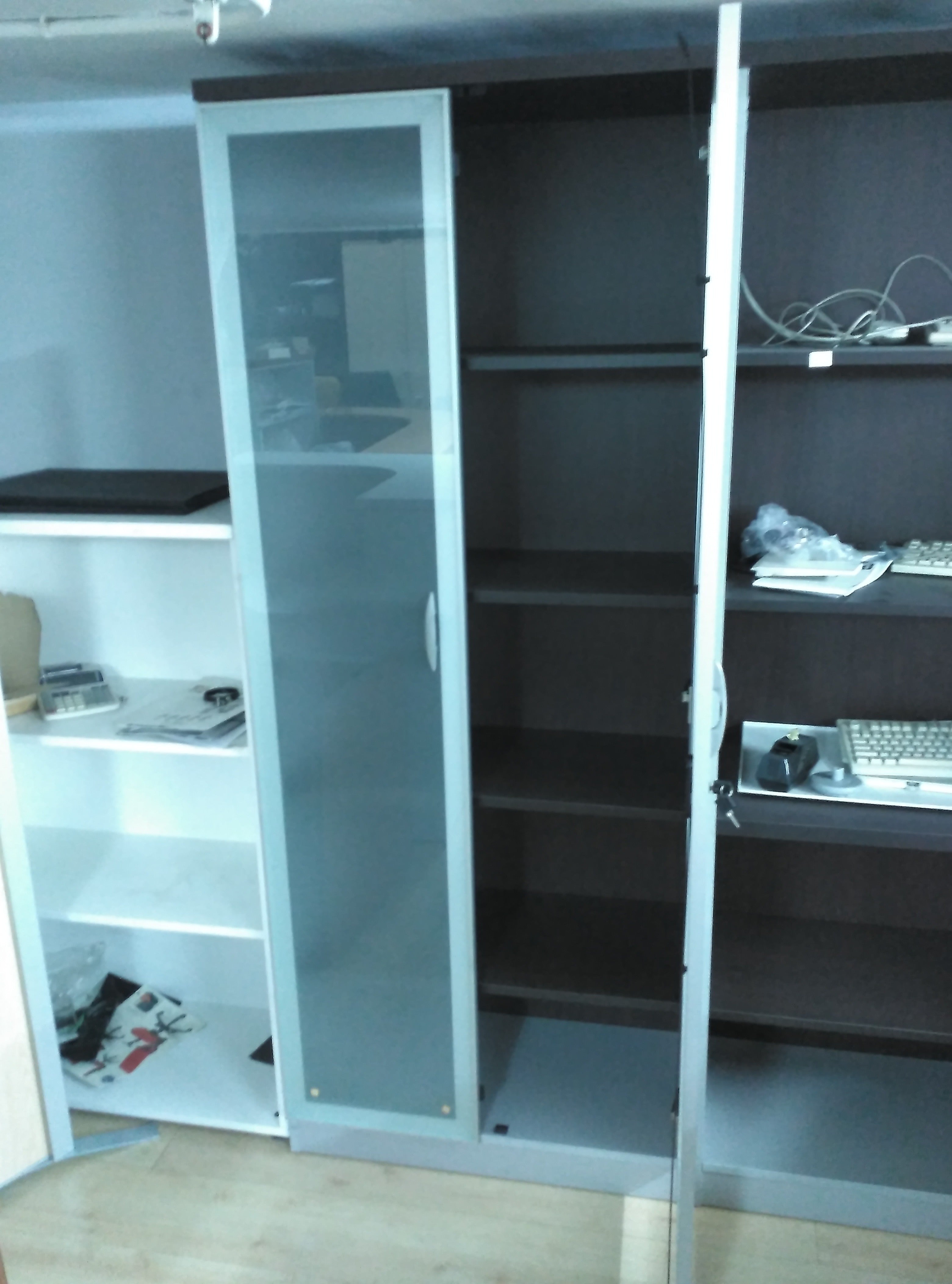 Armario alto con puertas de cristal.